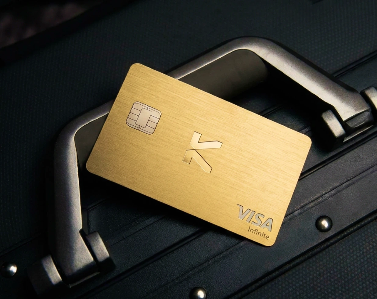 Gold KAST Visa Infinite card on a black travel case